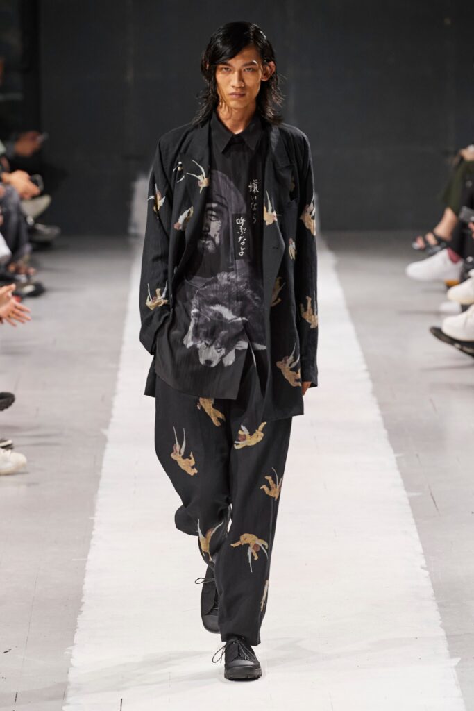 A relaxed black cotton shirt with long sleeves and a collared design, paired with matching printed pants.