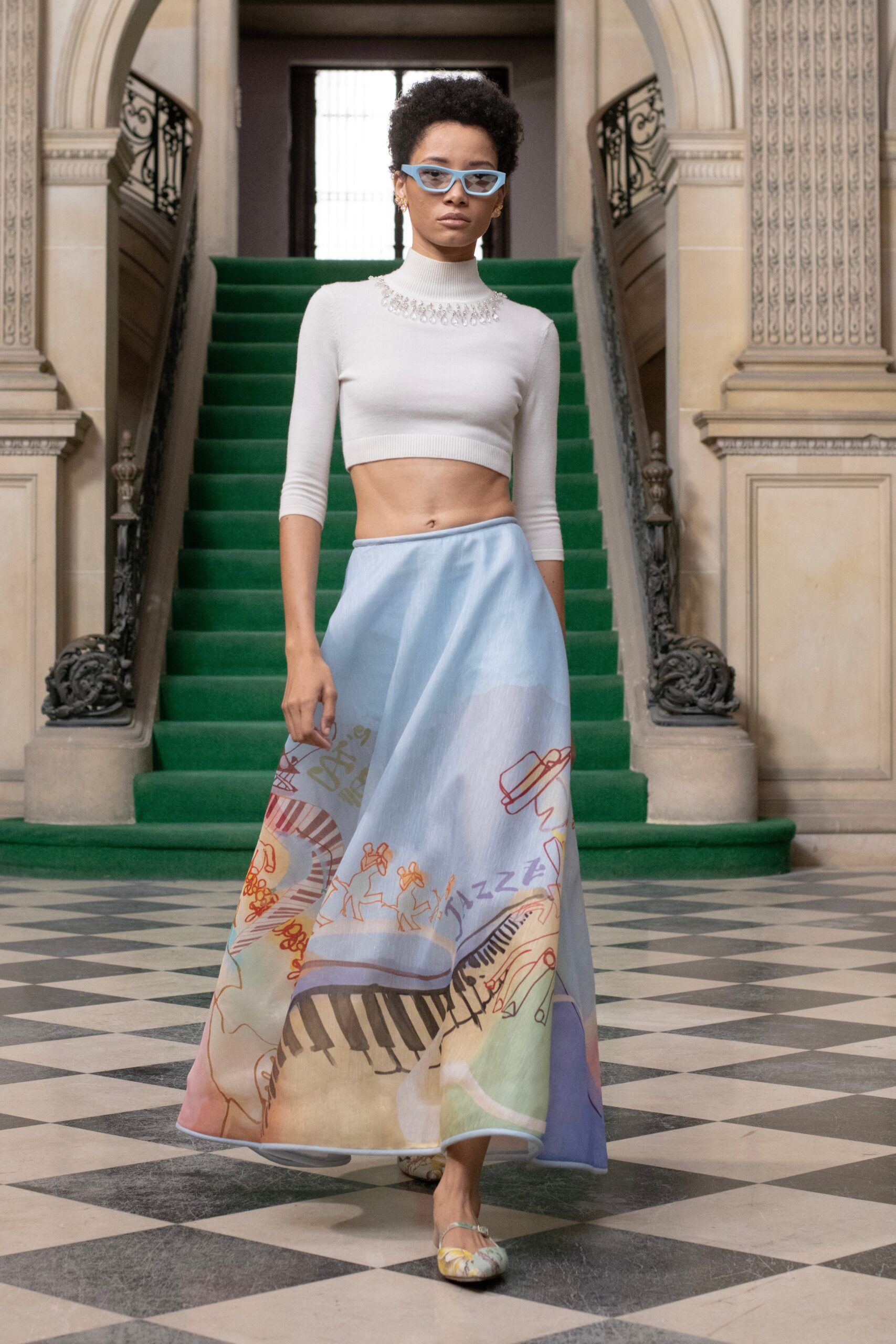 A fitted white long-sleeve top paired with a blue printed tiered skirt.