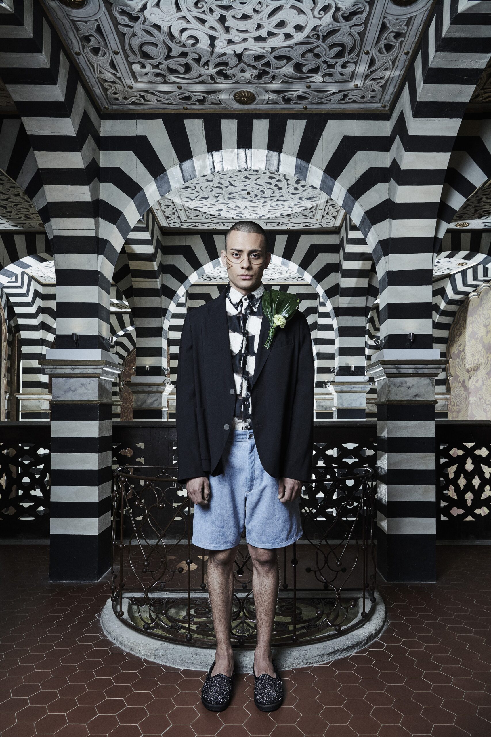 A relaxed black and white printed jacket paired with casual shorts.