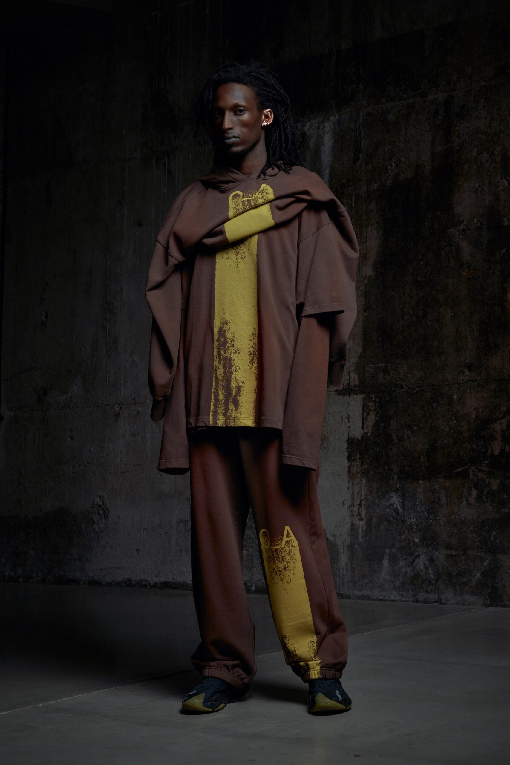 A relaxed brown hoodie with yellow print paired with matching pants for a casual look.