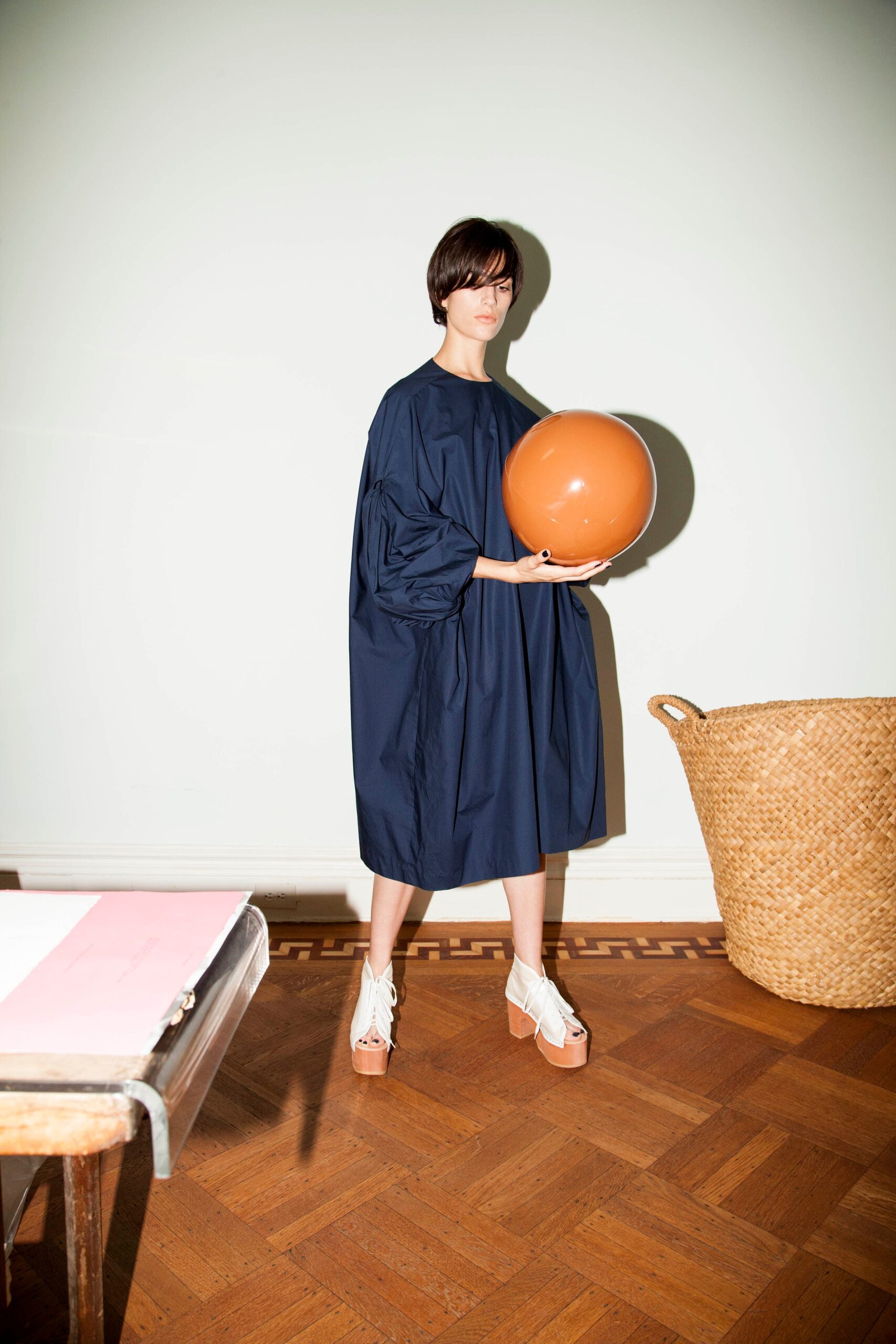 An oversized blue cotton dress with long sleeves and a draped design.