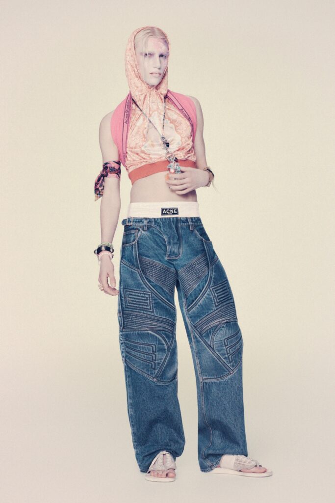A relaxed pink layered sleeveless top paired with wide-leg blue denim pants.