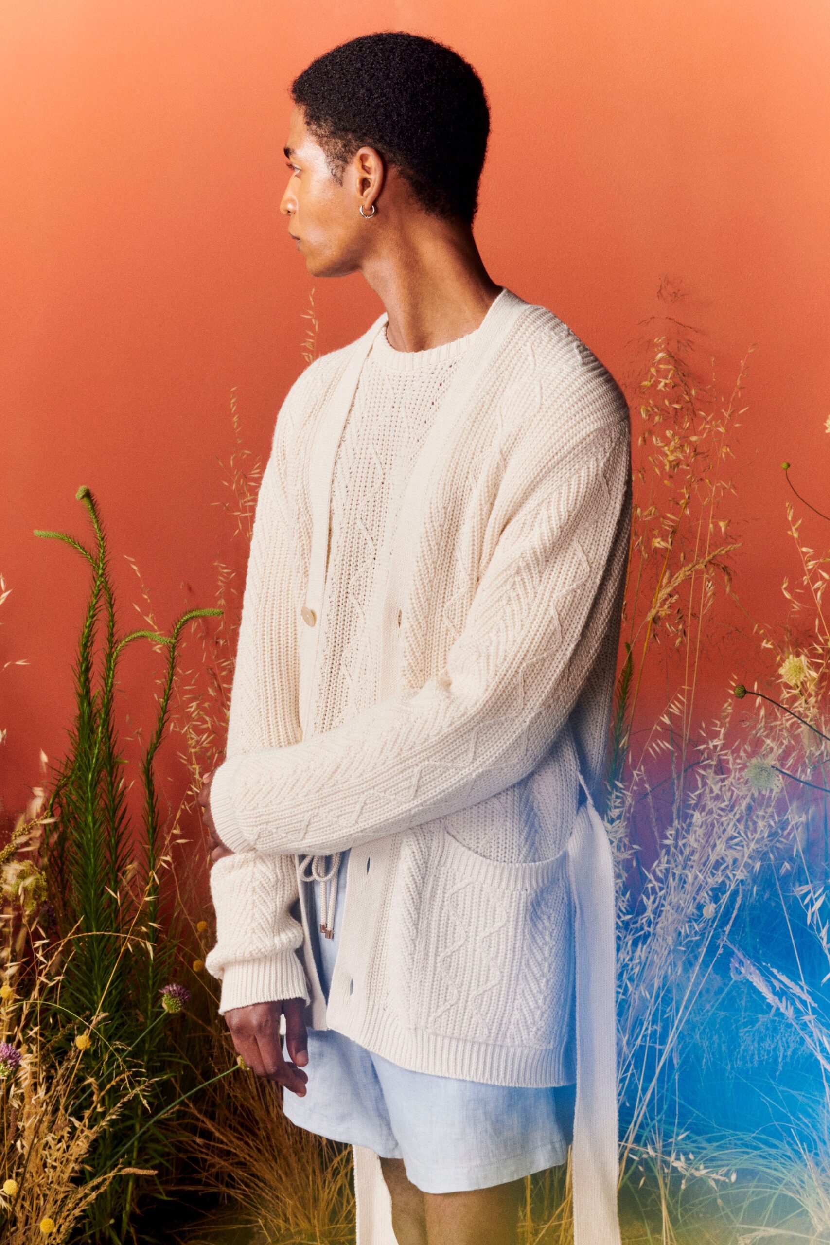 white knitted cardigan and blue shorts