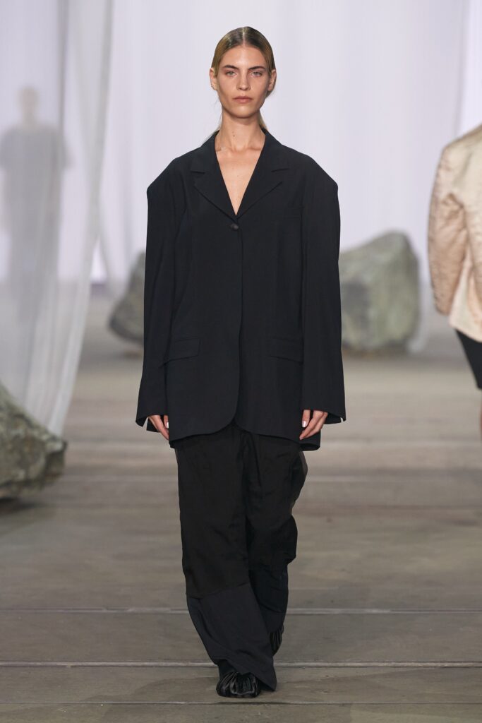 An oversized black jacket with a V-neck and straight-leg pants for a modern look.