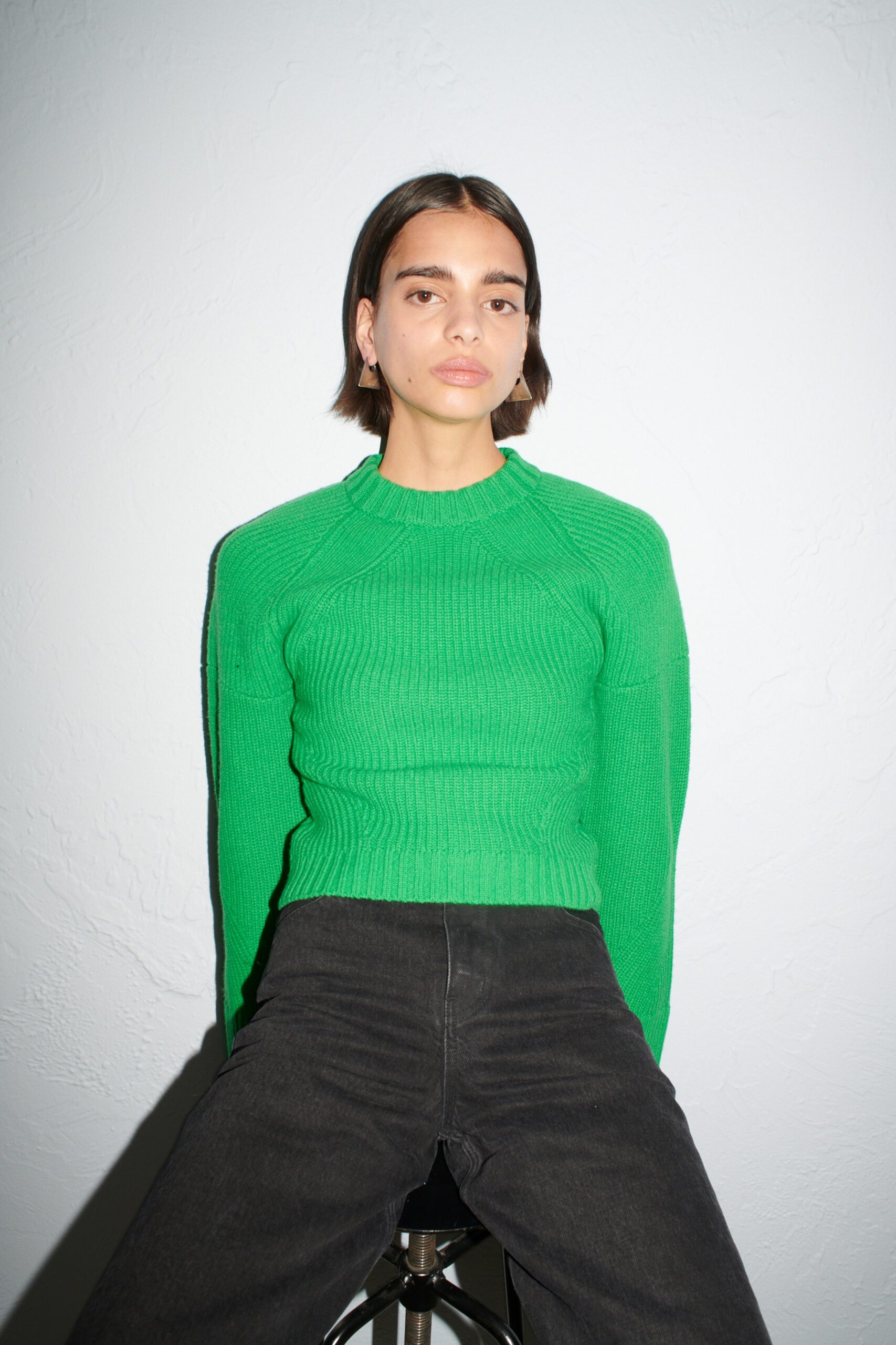 green fitted sweater with black pants