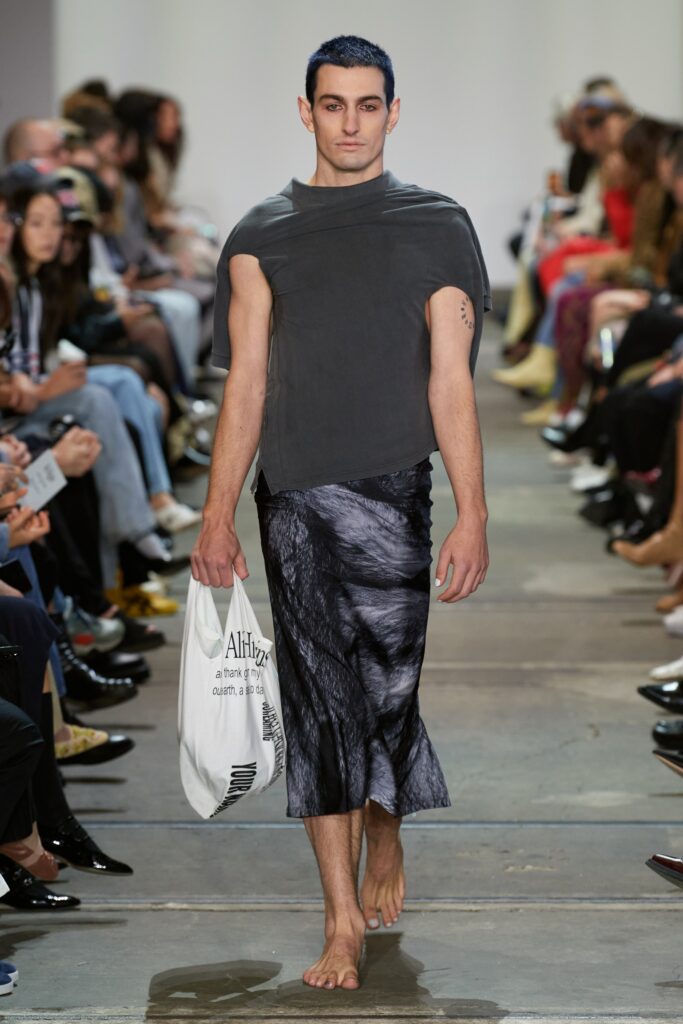 A relaxed black sleeveless top with a high-neck and an asymmetric skirt.