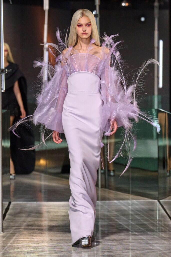 A fitted purple silk dress with a high neckline and draped design details.