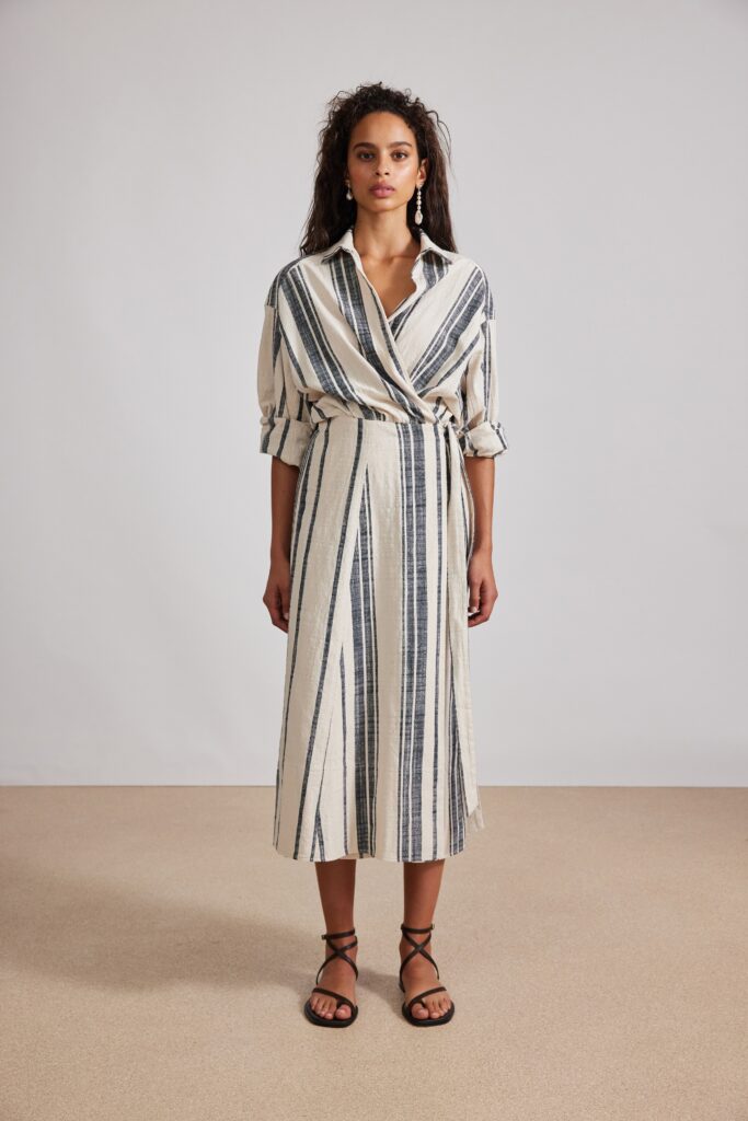 A relaxed beige and black striped dress with long sleeves and a belted waist.