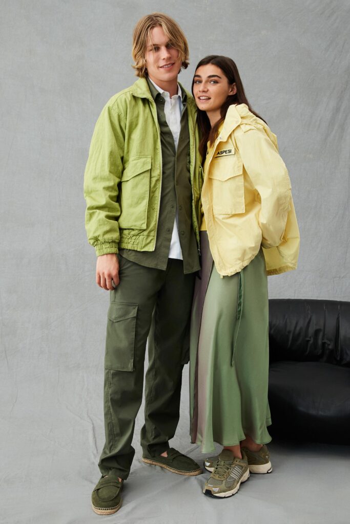 A relaxed green layered dress paired with a yellow long-sleeve jacket and collared shirt.