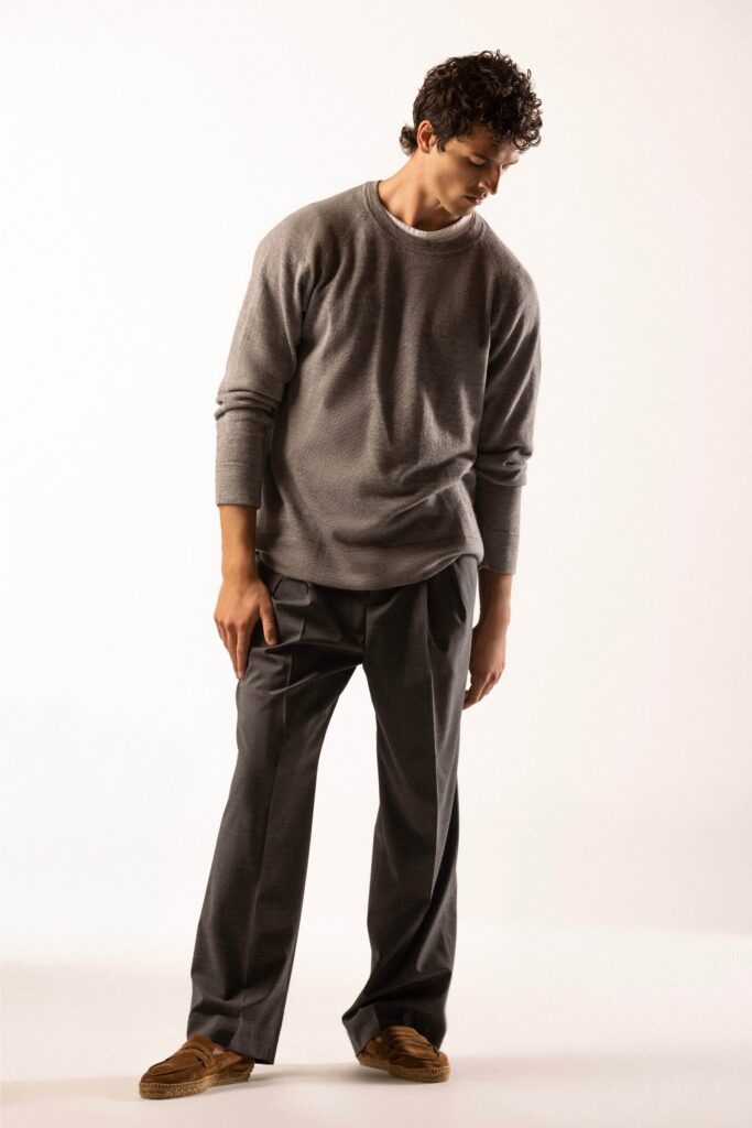 A relaxed gray long-sleeve sweater paired with straight-leg pants.