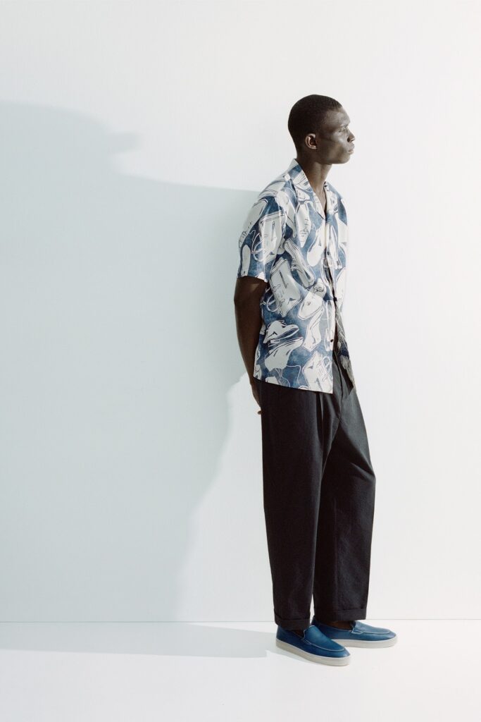 A relaxed blue printed shirt with short sleeves paired with black relaxed-fit pants.
