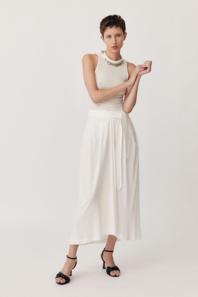 A fitted white sleeveless top paired with a tiered skirt for a chic look.