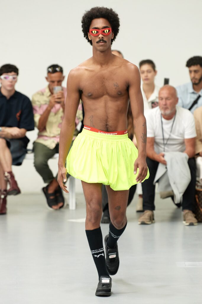A pair of relaxed yellow pleated shorts with a high-waisted design.
