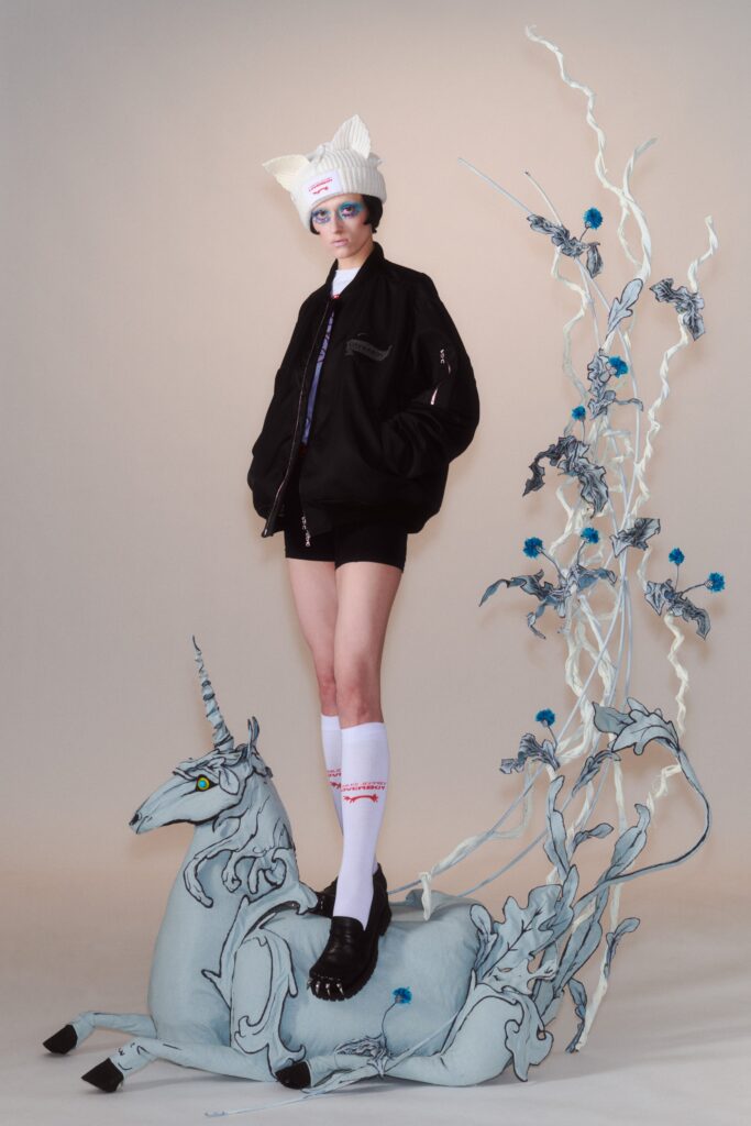 A relaxed black cotton jacket with long sleeves and a collared design, paired with shorts.