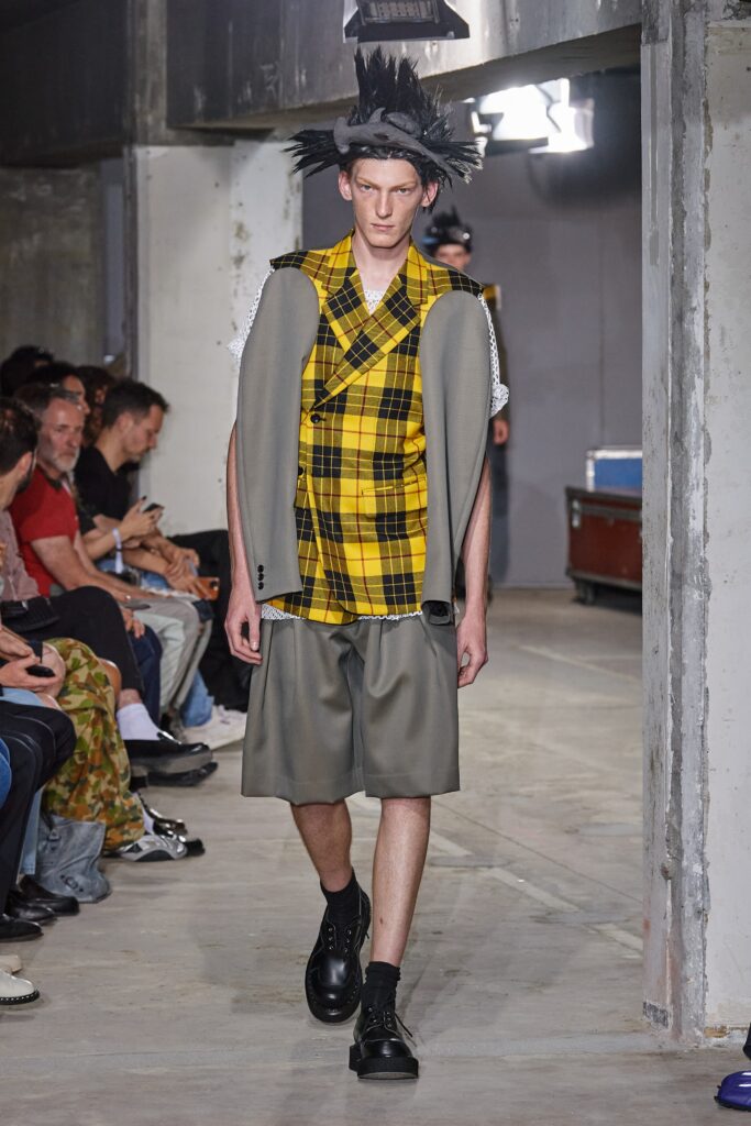 A relaxed fit yellow checked shirt paired with gray shorts featuring an asymmetric design.