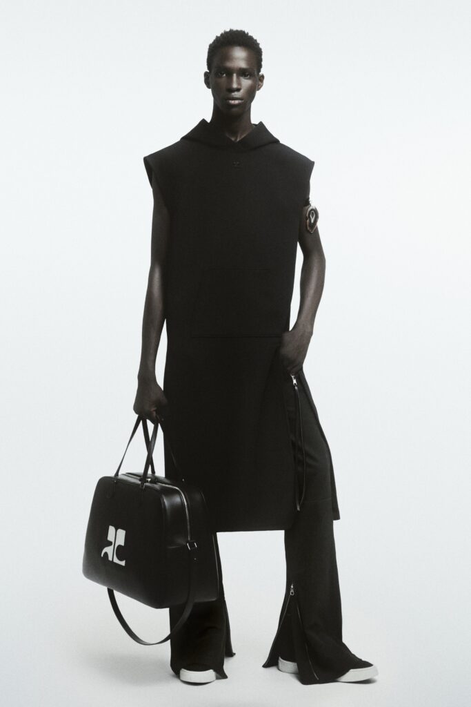 A relaxed black sleeveless dress with a hood and asymmetric design details.