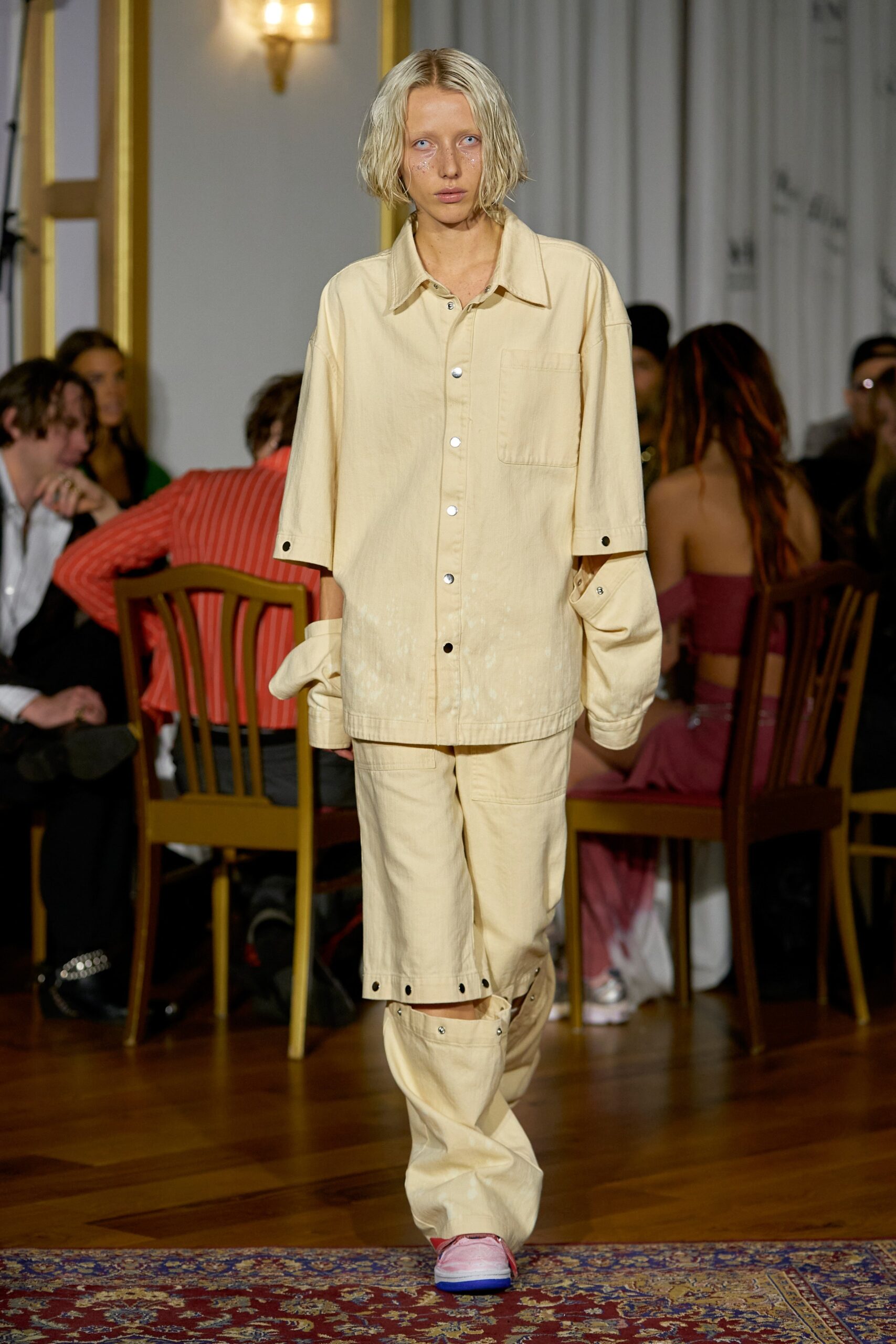 A relaxed beige cotton long-sleeve shirt with matching pants, featuring a collared design and buttoned details.