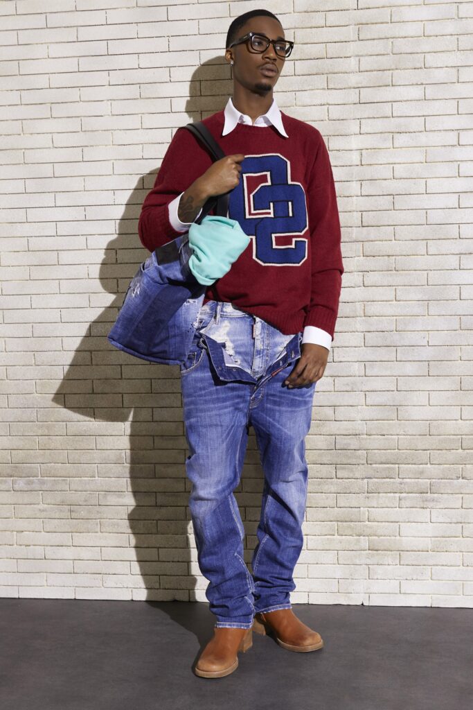 A relaxed red cotton sweater with a collared shirt underneath, paired with relaxed blue jeans.