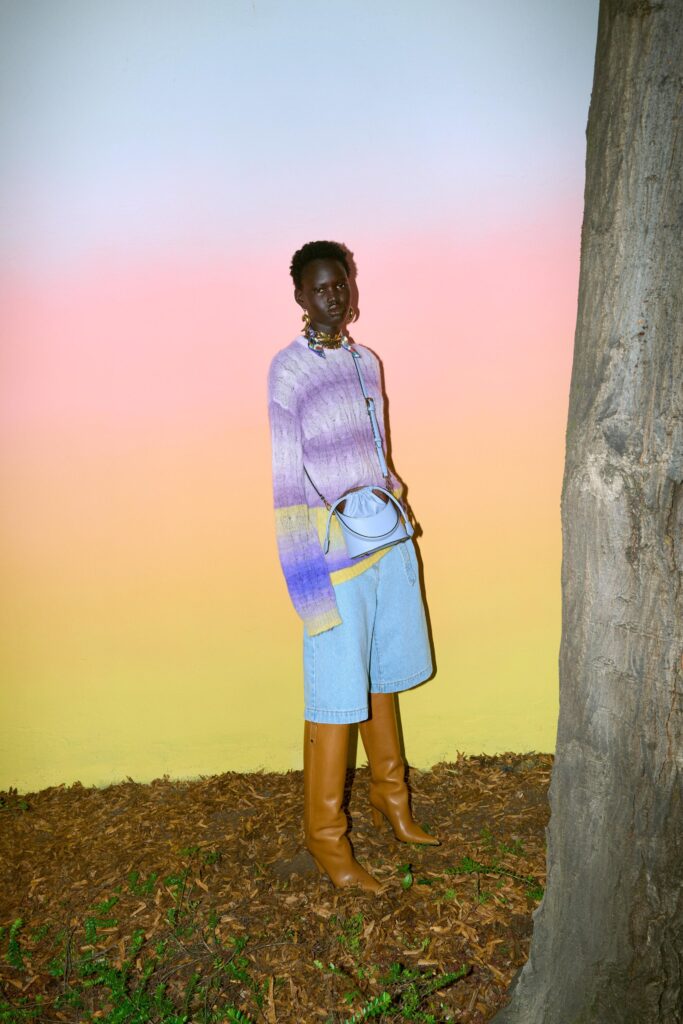 A relaxed purple striped long-sleeve sweater paired with wide-leg denim shorts.