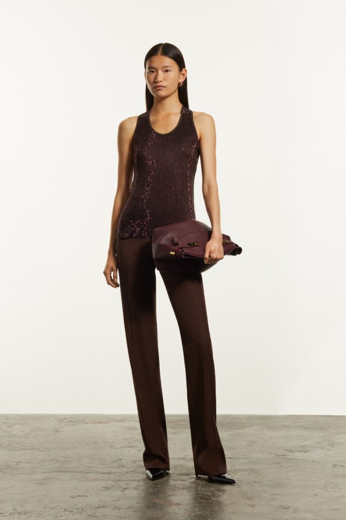 A fitted brown sequin sleeveless top paired with straight-leg burgundy pants.