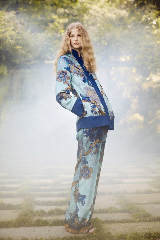 A relaxed blue silk jacket with long sleeves and a collared neckline, paired with matching printed pants.