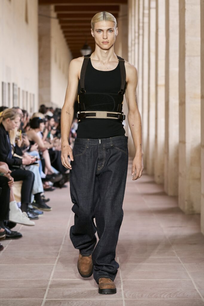 A relaxed black sleeveless top paired with wide-leg blue denim pants.