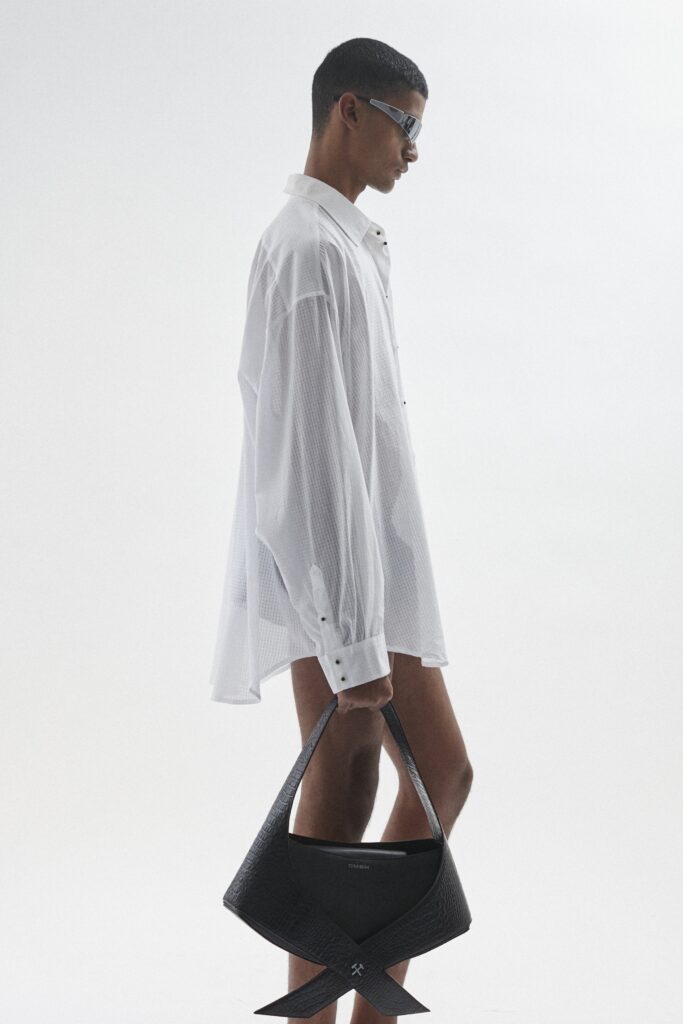 An oversized white cotton shirt with long sleeves and a collared design, featuring button details.