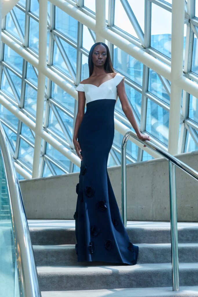 A fitted navy and white off-shoulder gown with a straight-leg silhouette.