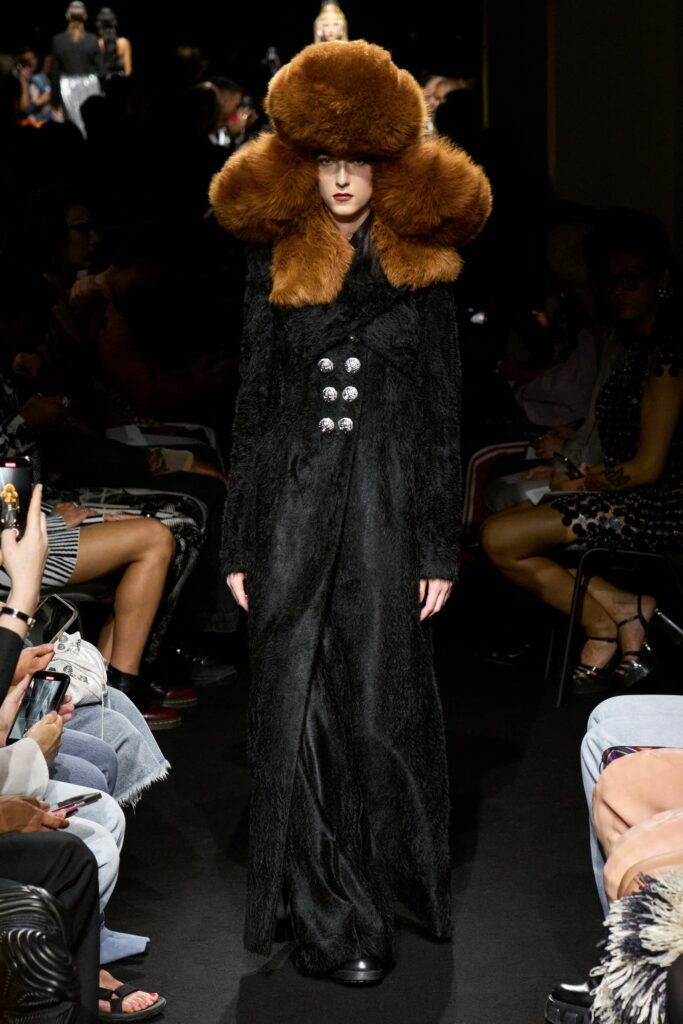 A fitted black fur coat with long sleeves and a collared design featuring button details.