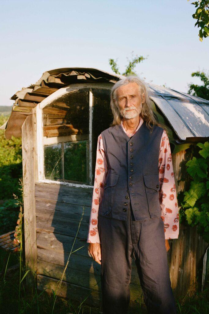 A relaxed blue cotton vest paired with white long-sleeve shirt and pants.