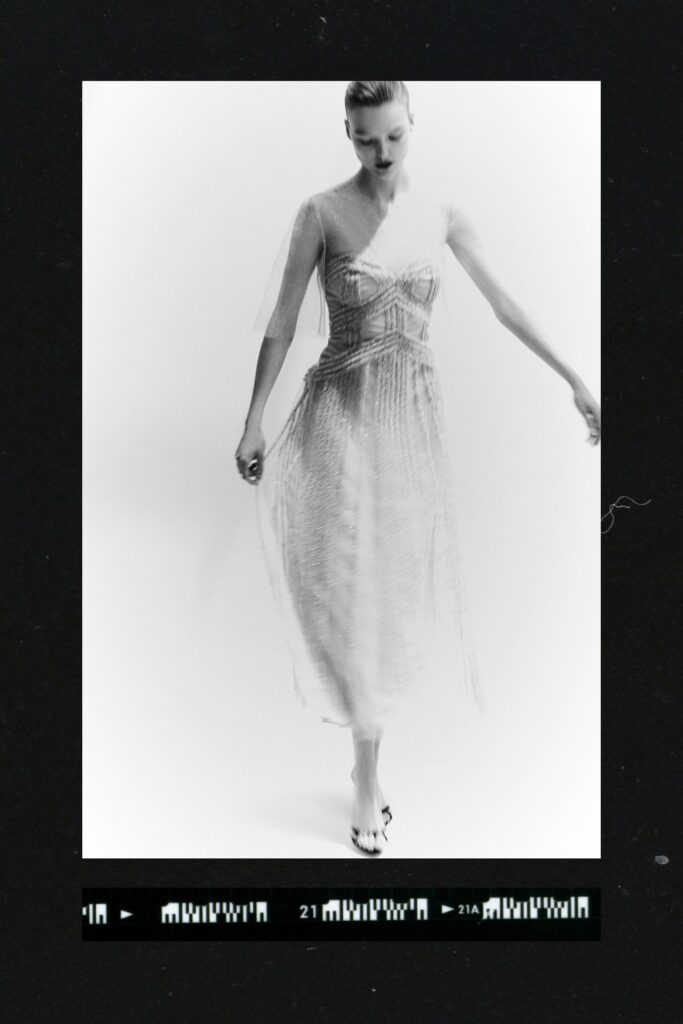 A relaxed white silk sleeveless dress with a V-neckline and tiered design.