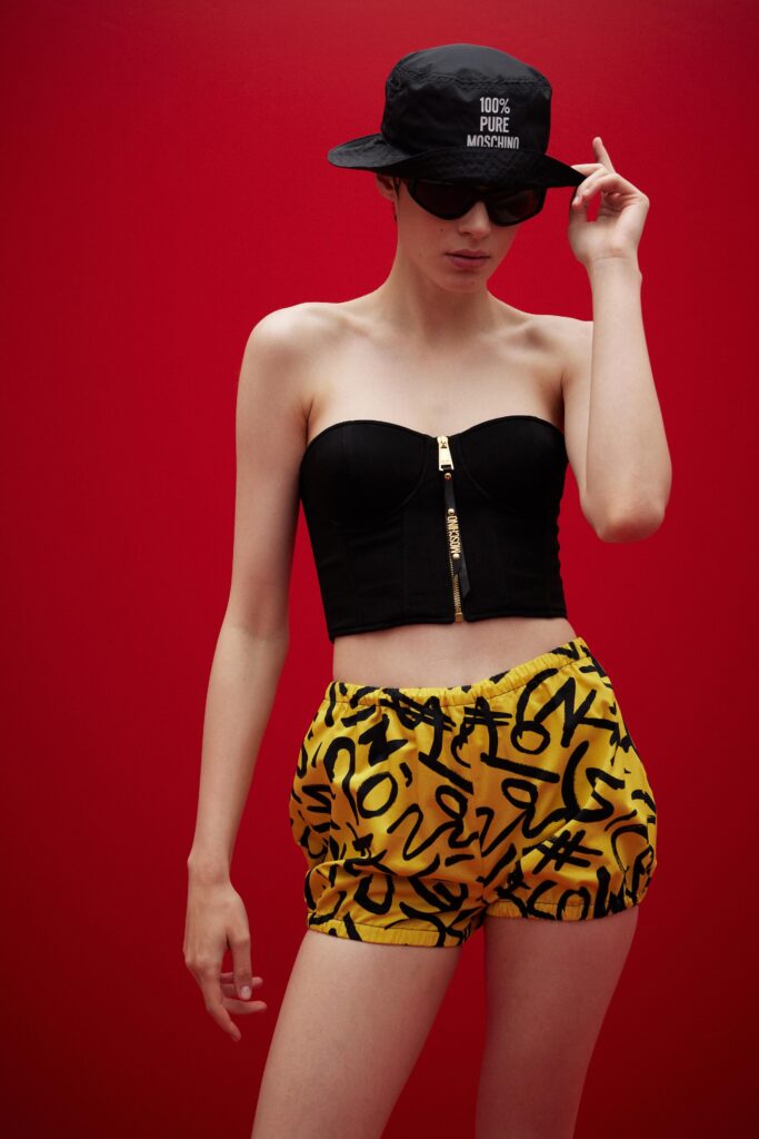 A fitted black strapless top paired with vibrant yellow printed shorts.