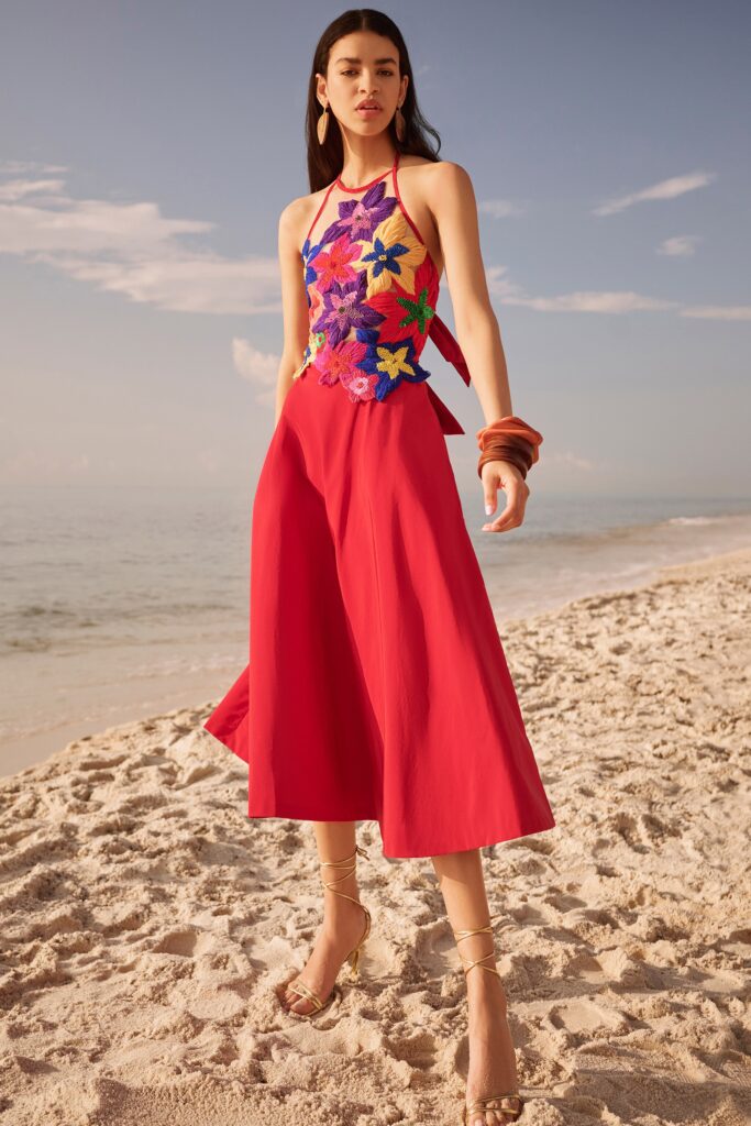 A relaxed red sleeveless dress with a V-neckline and flared silhouette, adorned with floral embroidery.