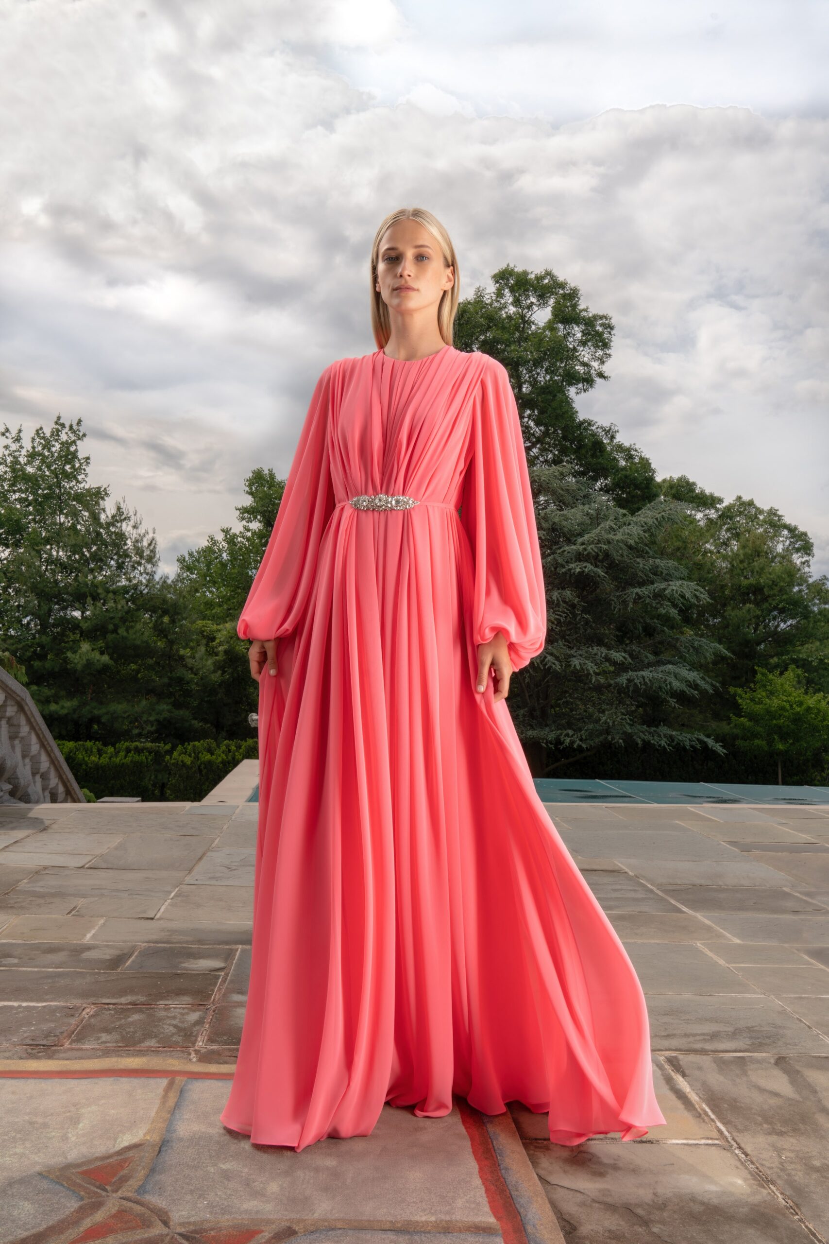 A relaxed pink silk long-sleeve gown featuring a V-neckline and flowy silhouette.