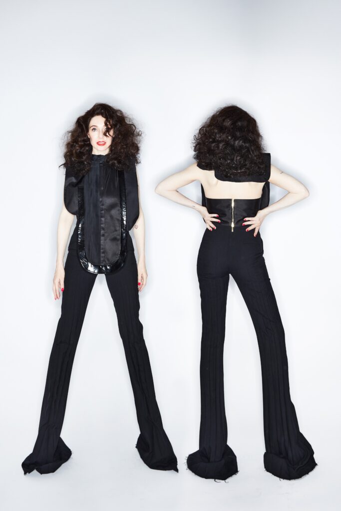 A fitted black sleeveless jumpsuit with a high-neck and flared silhouette.