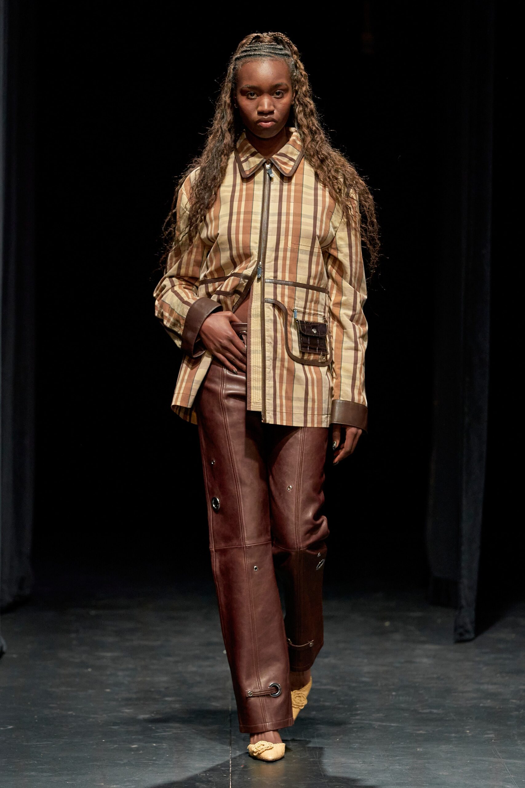 A relaxed brown striped jacket paired with brown leather pants featuring button details.