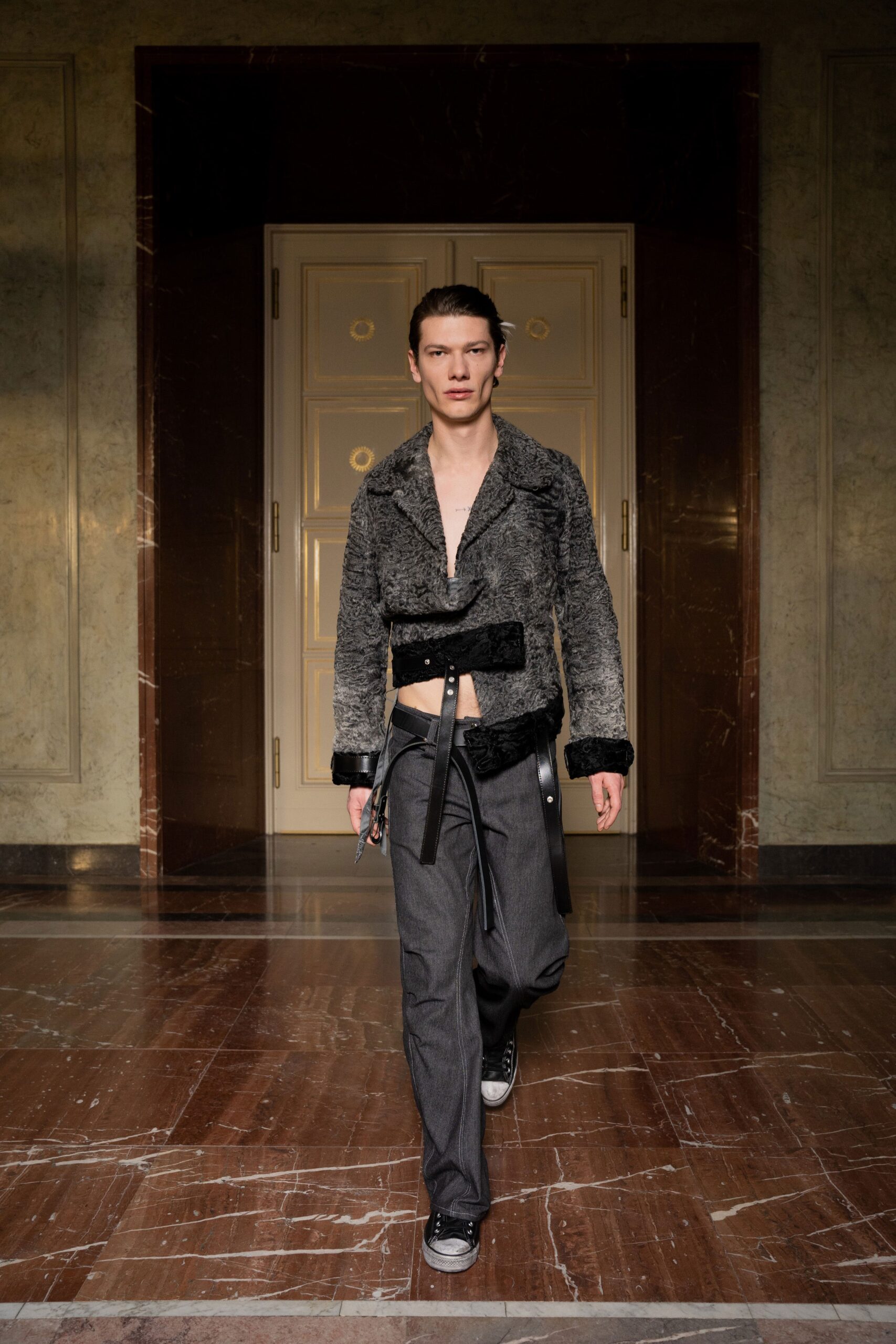 A fitted gray fur jacket paired with black pants, featuring a collared design and zippered details.