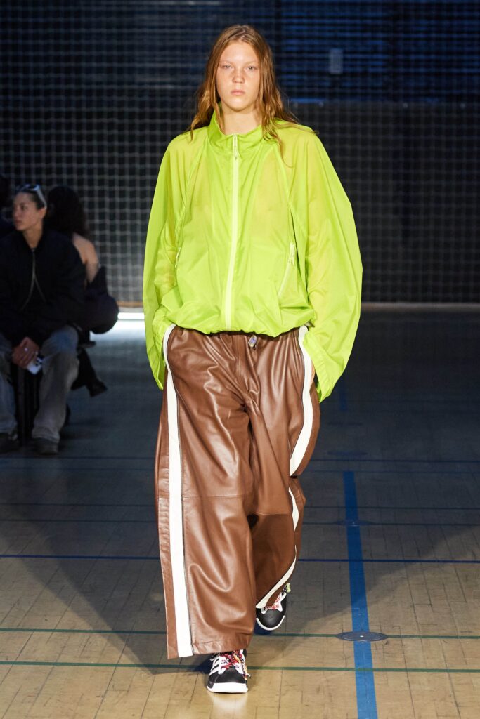 A relaxed green jacket with a collared neckline paired with wide-leg brown pants.