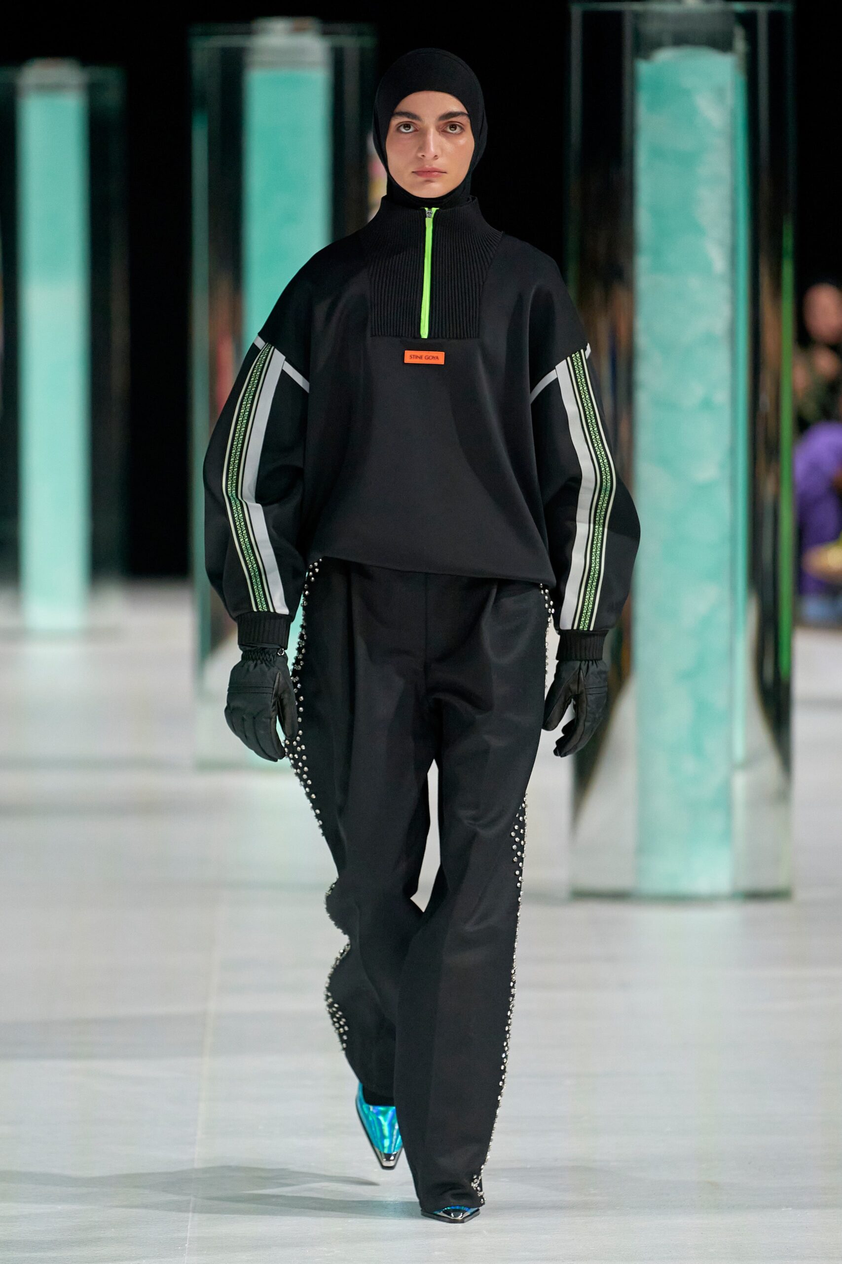 A relaxed black long-sleeve top with a high-neck and zippered detail paired with matching pants.