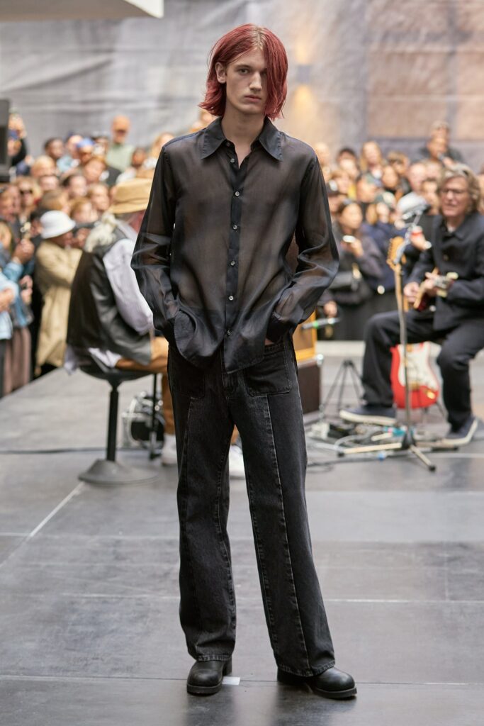 A relaxed black long-sleeve collared shirt paired with straight-leg black pants.