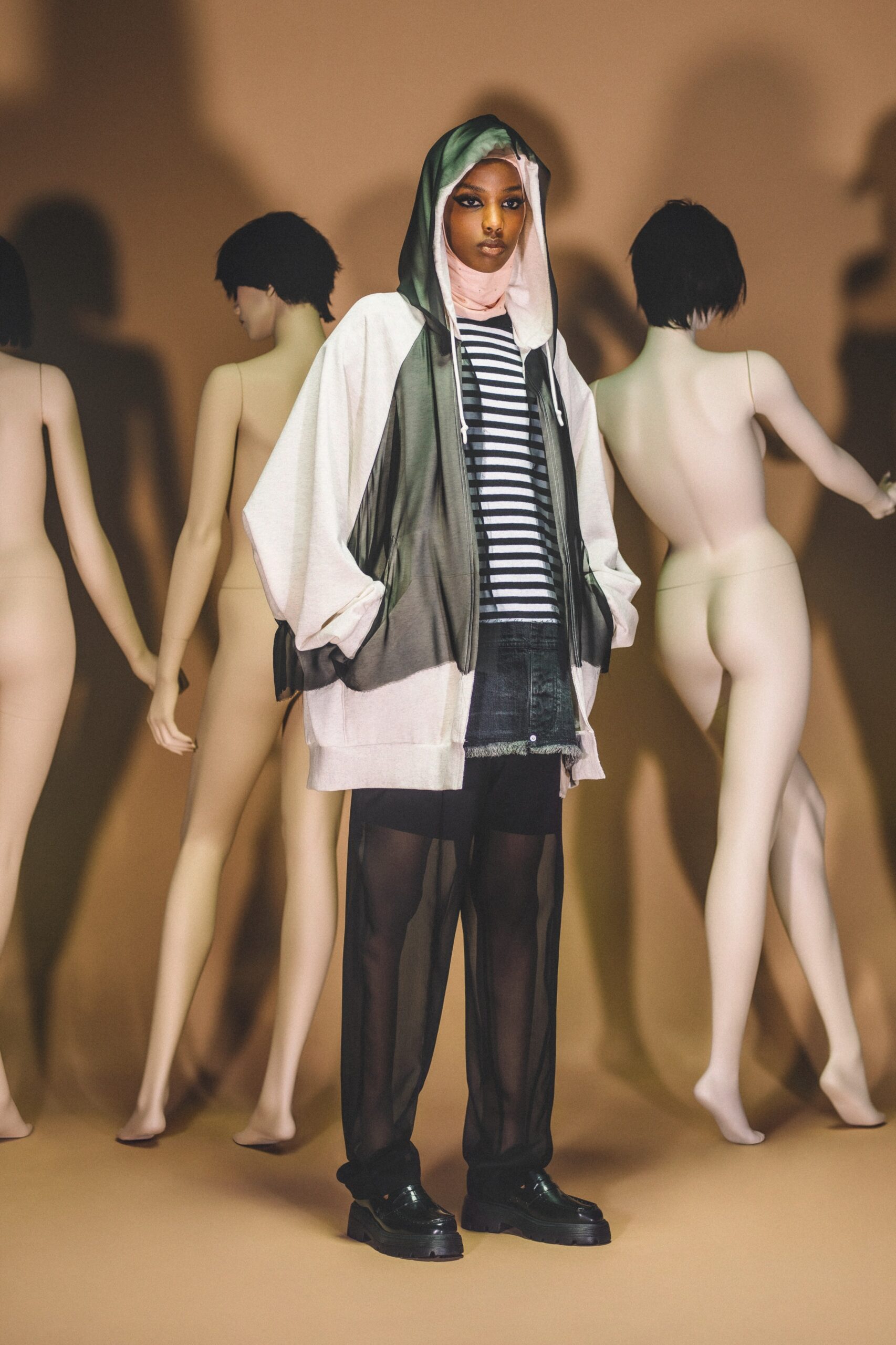 A relaxed black and white hooded jacket paired with sheer shorts featuring a striped design.