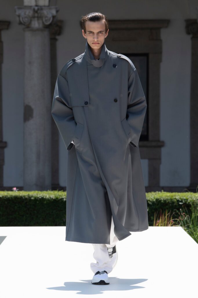 An oversized gray cotton coat with long sleeves and a collared design, featuring button details.
