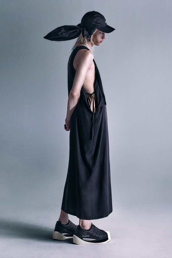 A relaxed black sleeveless dress with a V-neckline and asymmetric design.