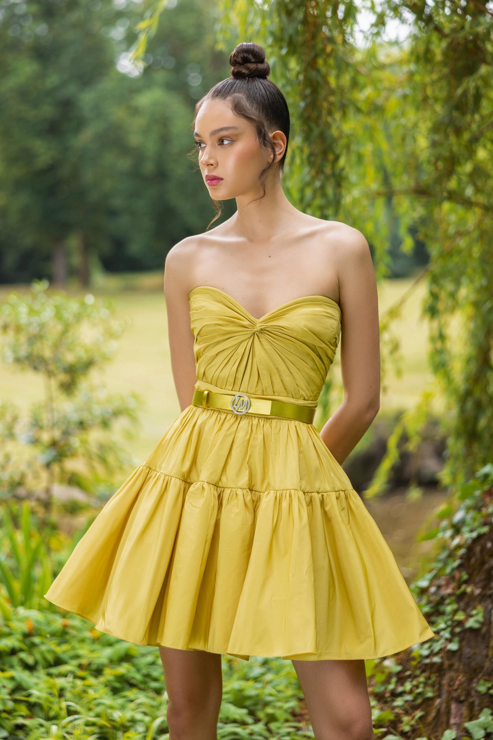 A fitted yellow strapless dress with a tiered silhouette, perfect for summer occasions.