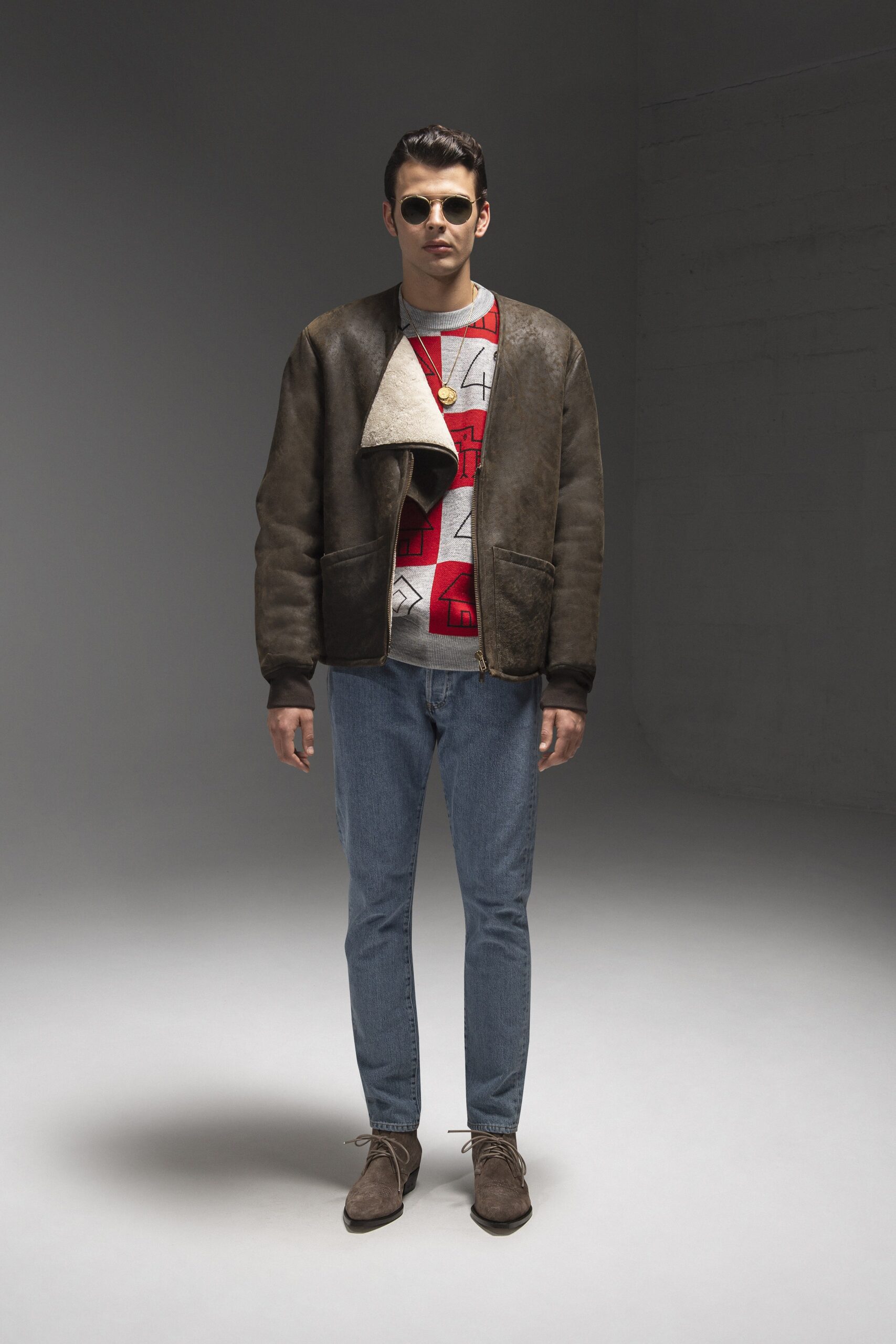 A fitted brown leather jacket paired with a long-sleeve printed shirt.