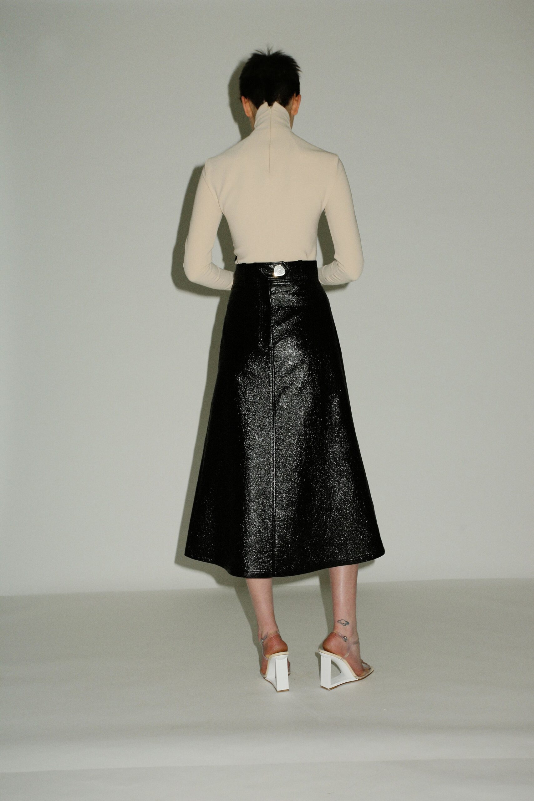 beige fitted top and black midi skirt