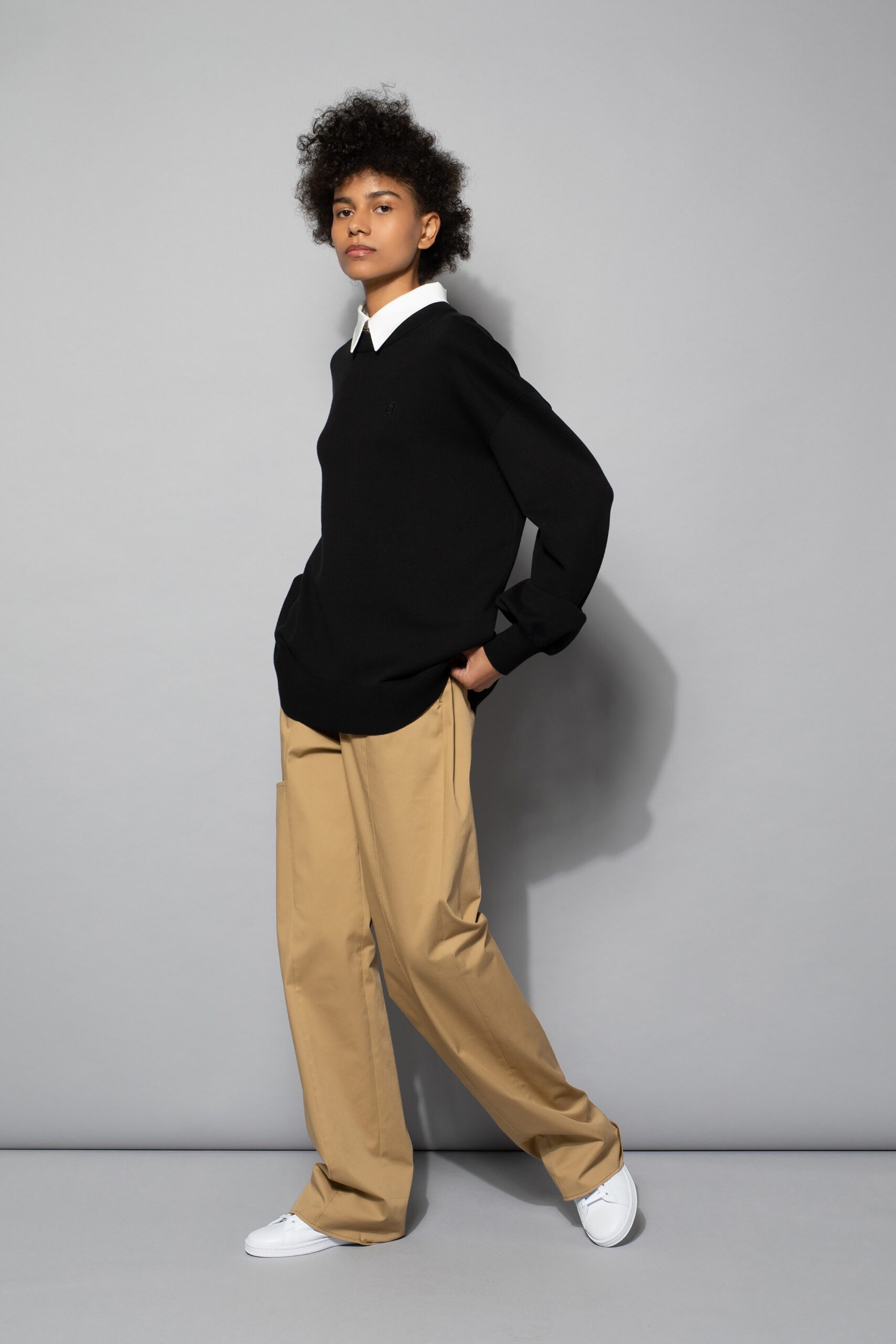black oversized sweater and beige pants