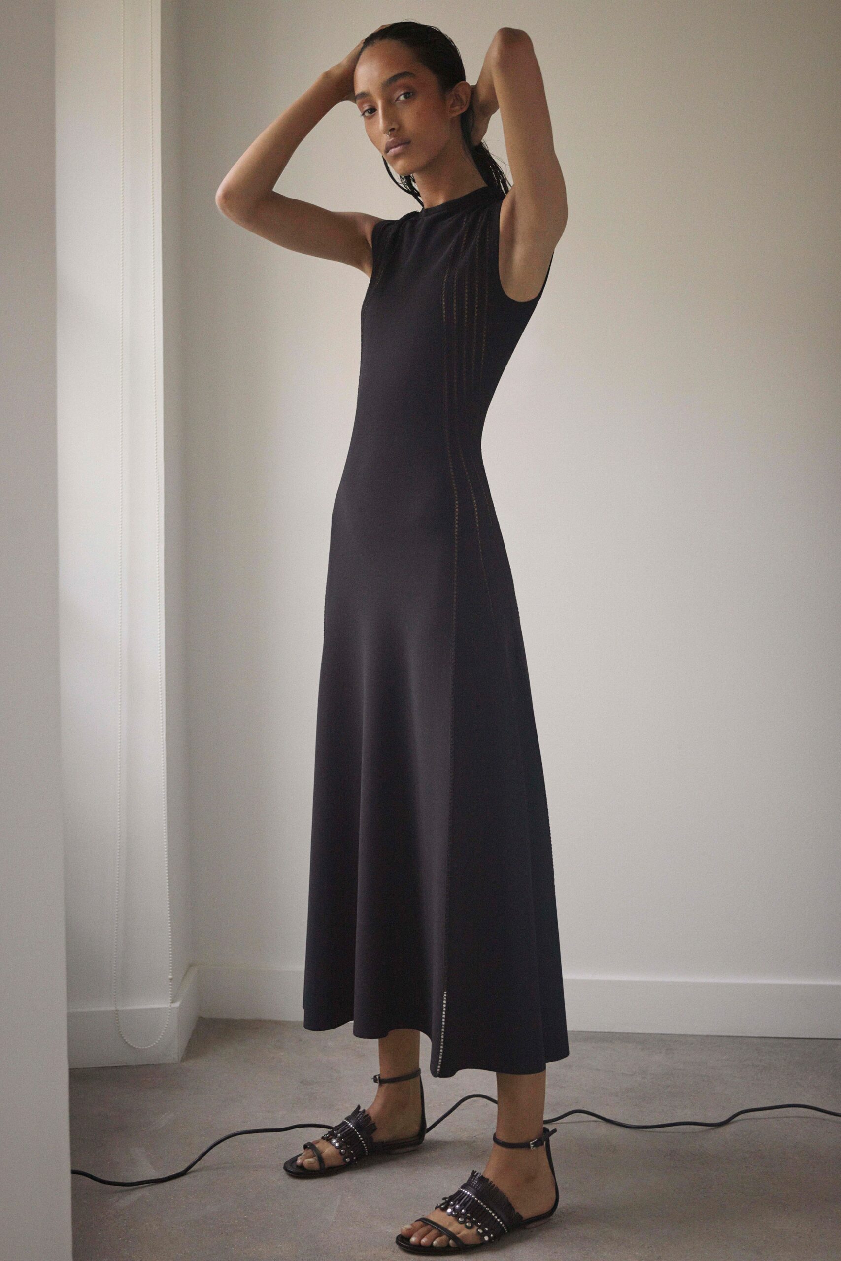 black fitted midi dress and strappy shoes