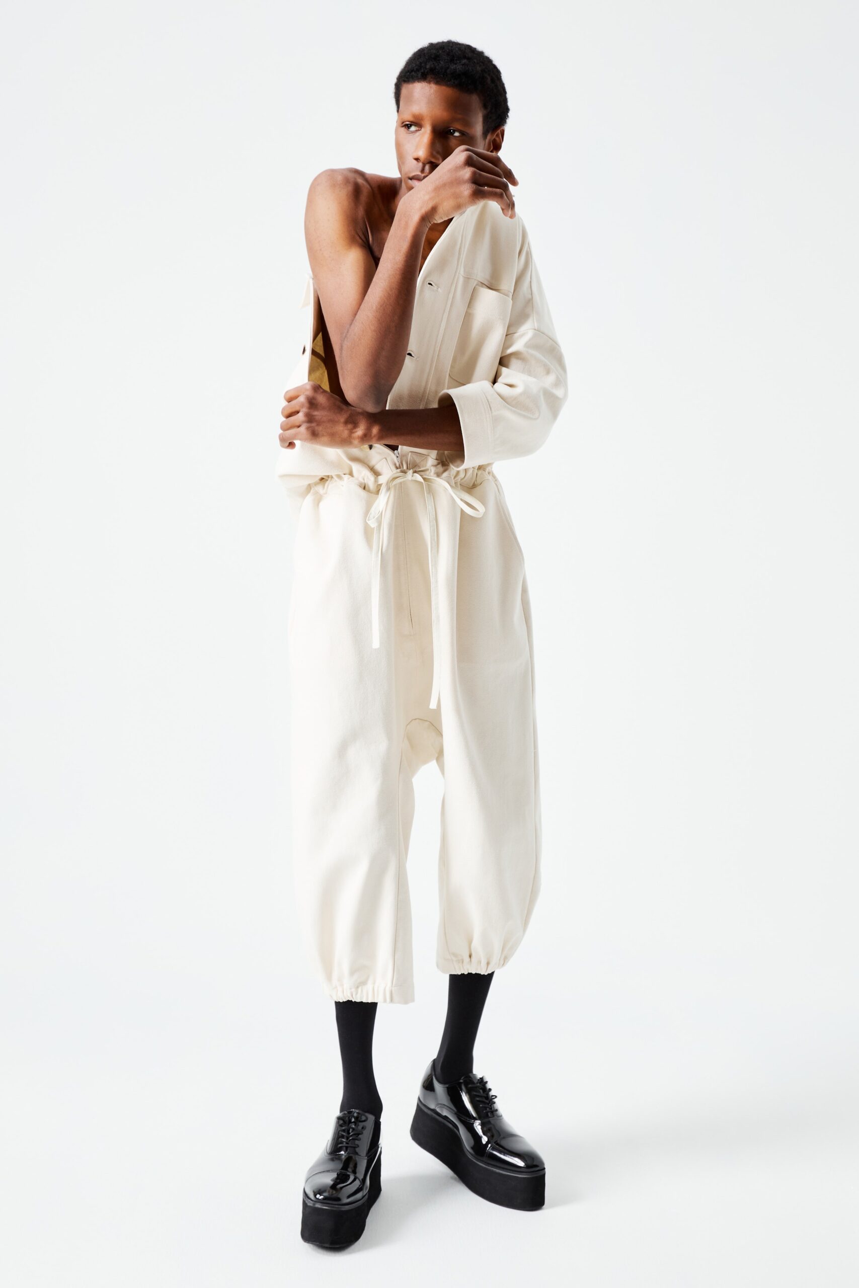 This relaxed jumpsuit features a unique asymmetric design, showcasing a long-sleeve and collared silhouette that adds an unexpected twist. The soft cotton fabric drapes effortlessly, creating a modern yet comfortable look that redefines casual elegance.