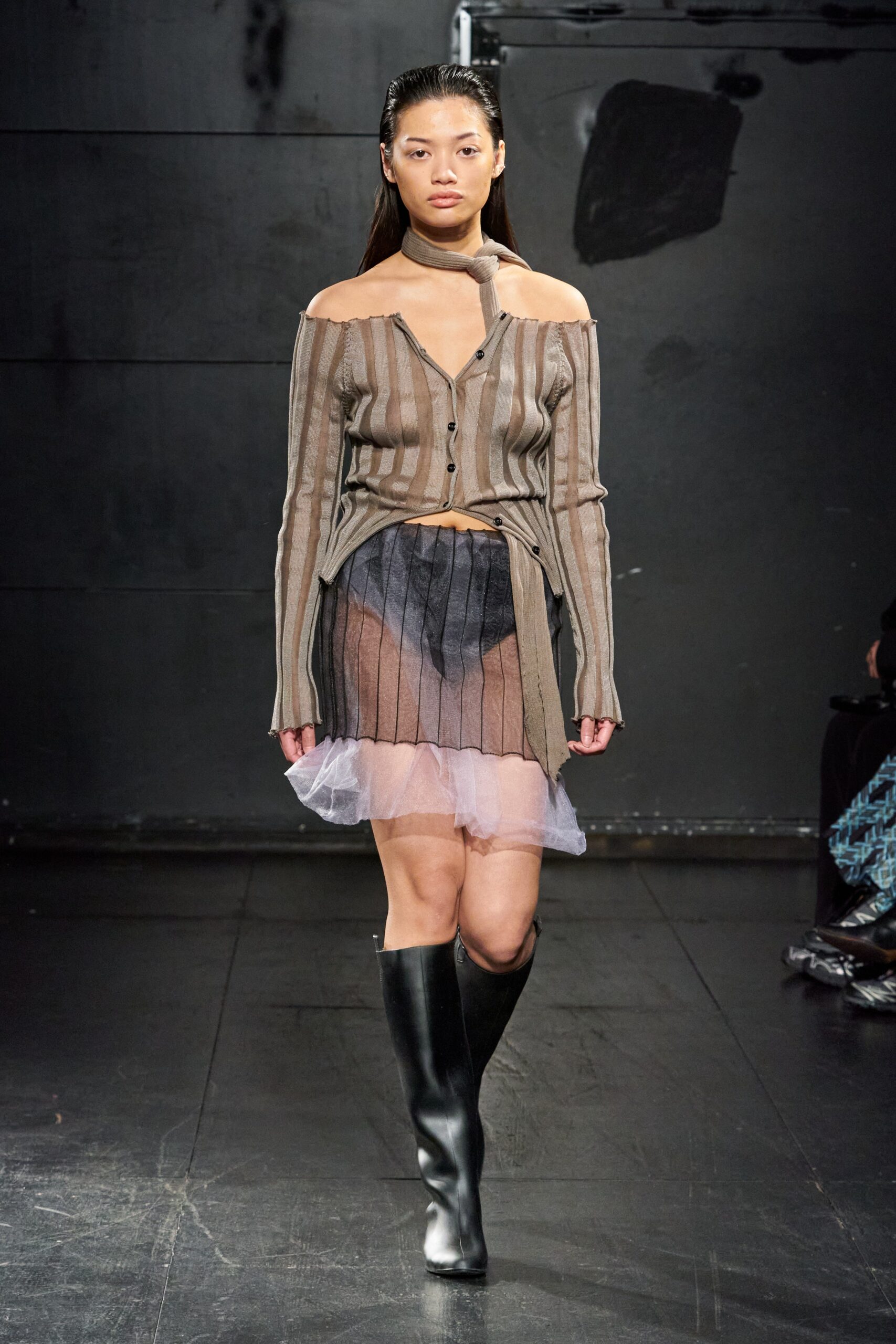 A fitted brown striped long-sleeve top paired with a layered black skirt.